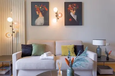 a living room with a couch and a painting of a woman at Alma Gallia 4 pers in Cannes