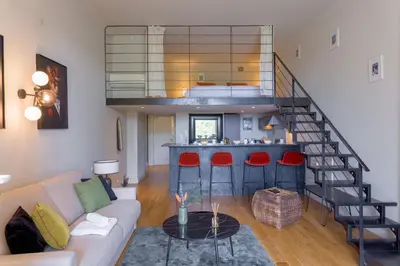 a living room with a couch and a staircase at Alma Gallia 4 pers in Cannes