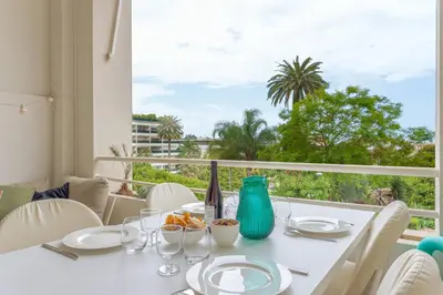 a dining room with a white table and a large window at Alma Gallia 4 pers in Cannes