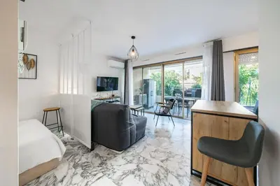 a bedroom with a bed and a living room at Studio avec terrasse et jardin arboré - 5 min hypercentre Cannes in Cannes