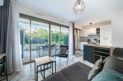 a kitchen and living room with a couch and a table at Studio avec terrasse et jardin arboré - 5 min hypercentre Cannes in Cannes