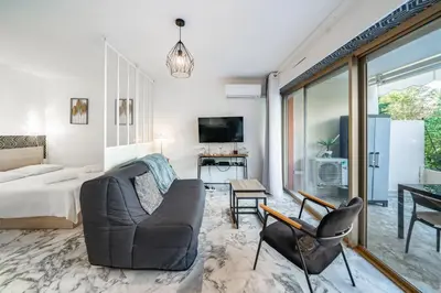 a living room with a bed and a couch at Studio avec terrasse et jardin arboré - 5 min hypercentre Cannes in Cannes