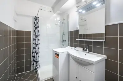 a white bathroom with a sink and a shower at Studio avec terrasse et jardin arboré - 5 min hypercentre Cannes in Cannes