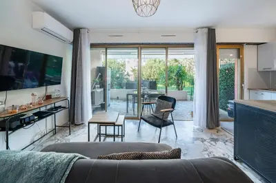 a living room with a couch and a table at Studio avec terrasse et jardin arboré - 5 min hypercentre Cannes in Cannes