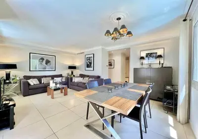 a living room with a table and a couch at Appartement de deux chambres à coucher près de la Croisette à Cannes in Cannes