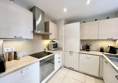 a kitchen with white cabinets and a microwave at Appartement de deux chambres à coucher près de la Croisette à Cannes in Cannes
