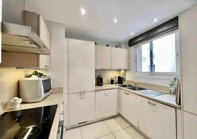 a kitchen with white cabinets and a microwave at Appartement de deux chambres à coucher près de la Croisette à Cannes in Cannes