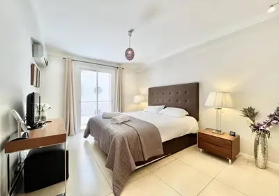 a bedroom with a bed and a tv in it at Appartement de deux chambres à coucher près de la Croisette à Cannes in Cannes