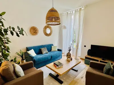 a living room with a blue couch and a coffee table at Sweett - Hotel Particulier Garden in Cannes