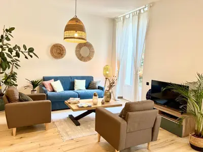 a living room with a blue couch and chairs at Sweett - Hotel Particulier Garden in Cannes