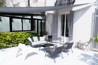a dining room with a table and some windows at Sweett - Hotel Particulier Garden in Cannes