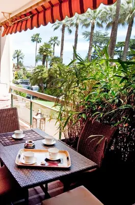 a table with a tray of food on a balcony at 90m2 Apartement - Les Palmiers de Cannes in Cannes