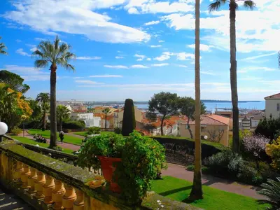 a view of the city from the gardens at 90m2 Apartement - Les Palmiers de Cannes in Cannes