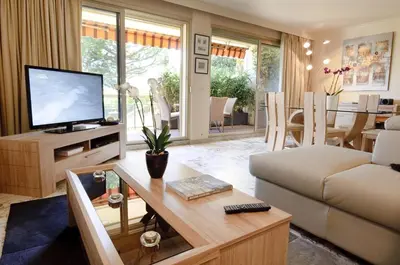 a living room with a couch and a television at 90m2 Apartement - Les Palmiers de Cannes in Cannes