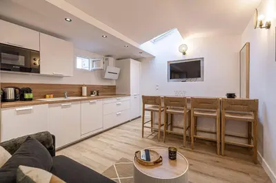 a kitchen and living room with a couch and a table at MEY T2 - Superbe appartement 4 pers, 50m du vieux port et 2min à pied du palais in Cannes