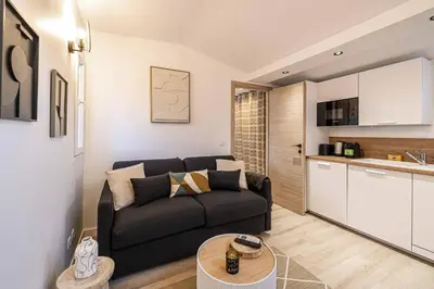 a living room with a couch and a kitchen at MEY T2 - Superbe appartement 4 pers, 50m du vieux port et 2min à pied du palais in Cannes