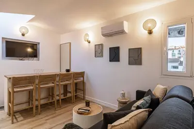 a living room with a couch and a table at MEY T2 - Superbe appartement 4 pers, 50m du vieux port et 2min à pied du palais in Cannes