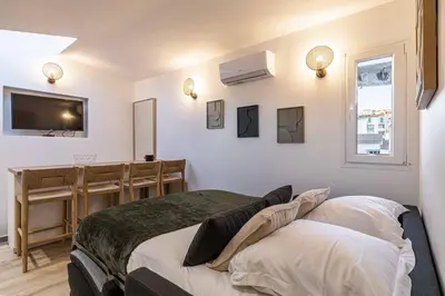 a bedroom with a bed and a television on the wall at MEY T2 - Superbe appartement 4 pers, 50m du vieux port et 2min à pied du palais in Cannes