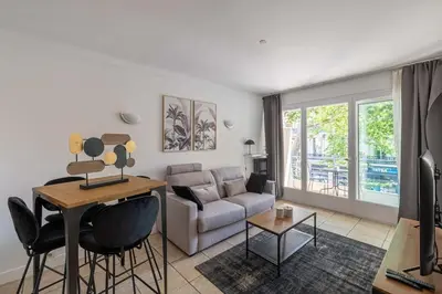 a living room with a couch and a table at 29 CARNOT - Chaleureux appartement avec balcon - centre ville in Cannes