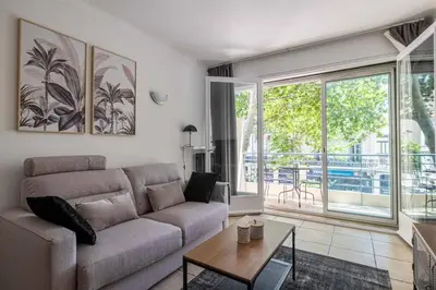 a living room with a couch and a table at 29 CARNOT - Chaleureux appartement avec balcon - centre ville in Cannes