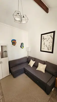 a living room with a black couch in a room at PROCHE CONGRES PLAGES CLIM in Cannes