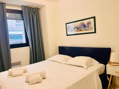 a bedroom with a white bed and a window at Cannes en plein cœur in Cannes