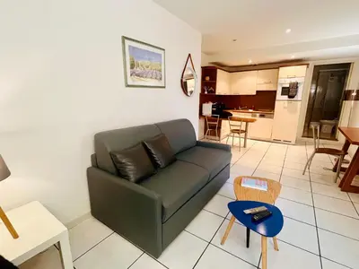 a living room with a couch and a kitchen at Cannes en plein cœur in Cannes
