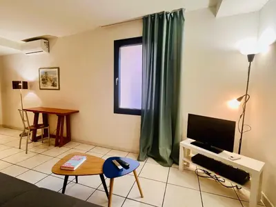 a living room with a television and a table at Cannes en plein cœur in Cannes