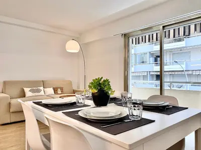 a dining room table with plates and glasses on it at Appartement Cannes 2 chambres - 14J in Cannes