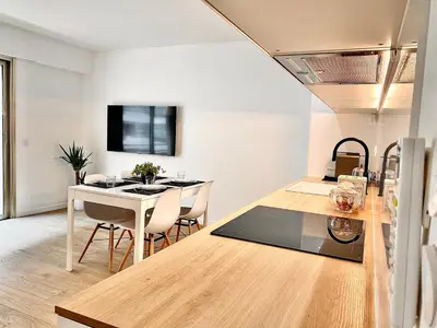 a kitchen and living room with a table and chairs at Appartement Cannes 2 chambres - 14J in Cannes