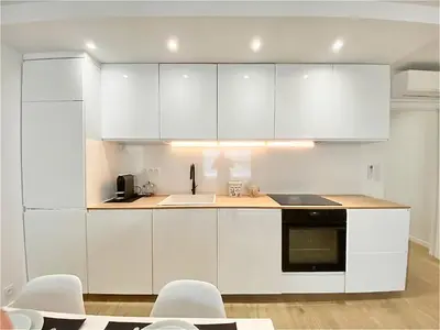 a white kitchen with white cabinets and white appliances at Appartement Cannes 2 chambres - 14J in Cannes