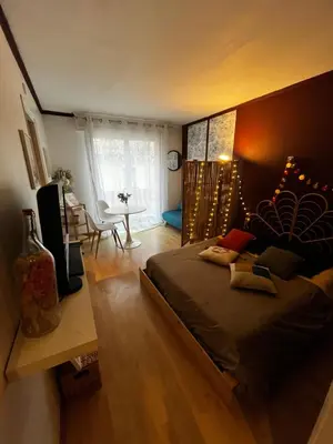 a bedroom with a large bed and a living room at Cosy Studio - Plage et Suquet in Cannes