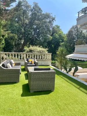 a garden with three couches on the grass at Luxus Wohnung nahe Croisette in Cannes