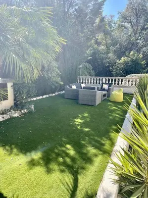 a garden with a couch in the grass at Luxus Wohnung nahe Croisette in Cannes