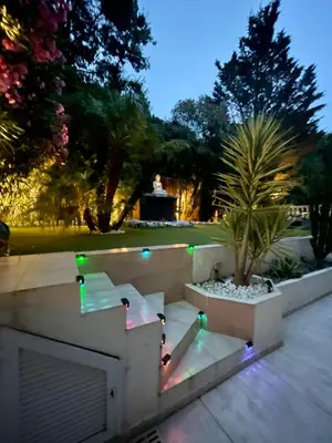 a patio with lights and a palm tree at night at Luxus Wohnung nahe Croisette in Cannes