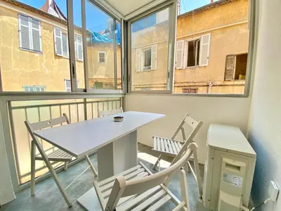 a table and chairs on a balcony with a window at La Bergerie By SCLS Locations in Cannes