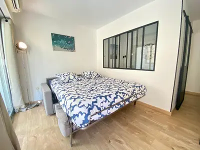 a bedroom with a bed with a blue and white comforter at La Bergerie By SCLS Locations in Cannes