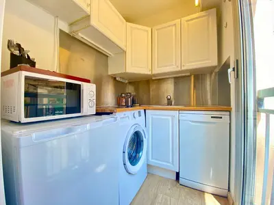 a kitchen with a washing machine and a microwave at La Bergerie By SCLS Locations in Cannes
