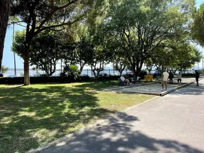 a park with trees and people sitting on the grass at Beach Studio Cannes in Cannes
