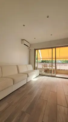 a living room with a white couch and a large window at Beach Studio Cannes in Cannes