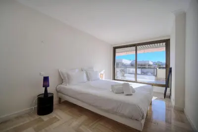 a white bedroom with a large bed and a window at REF 1174 - Apartment with Sea View in Cannes