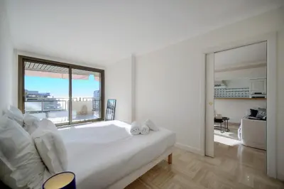 a bedroom with a large white bed with a large window at REF 1174 - Apartment with Sea View in Cannes