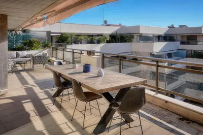 a wooden table and chairs on a balcony at REF 1174 - Apartment with Sea View in Cannes