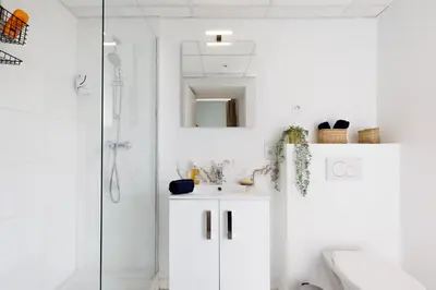 a white bathroom with a sink and a shower at Centre studio plage et festival in Cannes