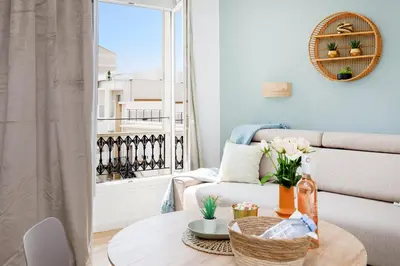 a living room with a table and a couch and a window at Centre studio plage et festival in Cannes