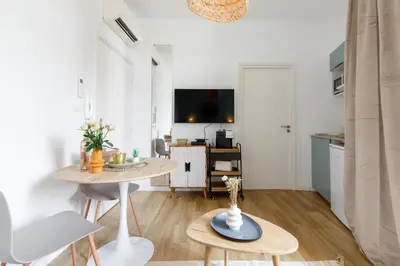 a small living room with a table and a kitchen at Centre studio plage et festival in Cannes