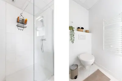 a white bathroom with a shower and a toilet at Centre studio plage et festival in Cannes