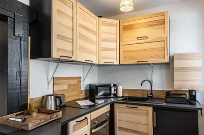 a kitchen with wooden cabinets and a counter top at 3 LEGOF - Charmant appartement 4 couchages centre Cannes in Cannes