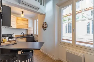 a kitchen with a table and chairs and a window at 3 LEGOF - Charmant appartement 4 couchages centre Cannes in Cannes
