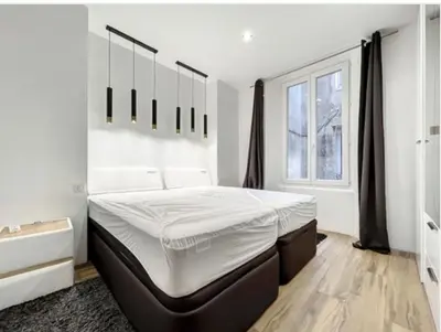a white bedroom with a large bed and a window at Appartement Palais des Festivals in Cannes